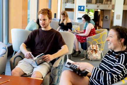 Students reading and studying together in the library on the skybridge., 
