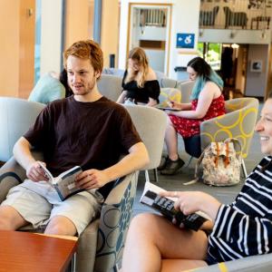 Students reading and studying together in the library on the skybridge., 