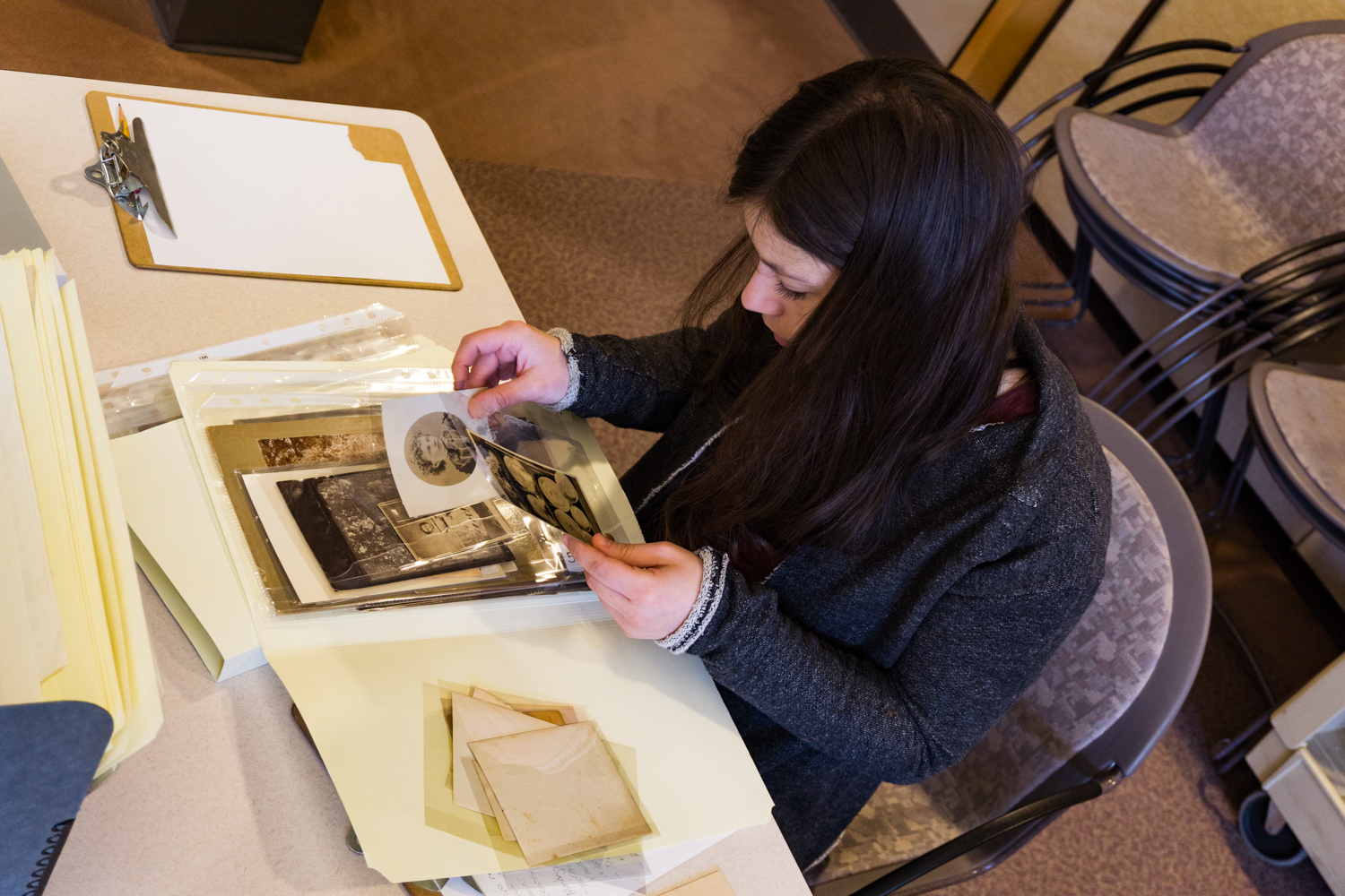 Student looking at historical photographs during a class visit to the Archives Building.