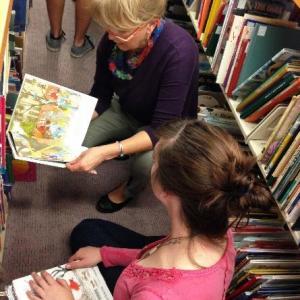 Two women reading children's books with pictures